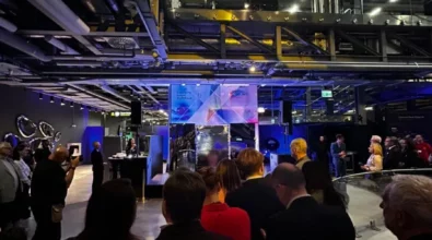 Zdjęcie przedstawiające scenę z tłem z grafiką przedstawiającą twarz w różnych odbiciach lustra. Na grafice znajduje się napis \