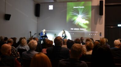 Publiczność obserwuje rozmowę dwóch osób na scenie.