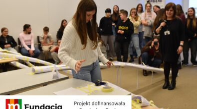 Uczennica prezentuje długą papierową konstrukcję. Na dole logotyp Fundacji mBanku.