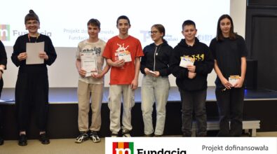 Siedem osób pozuje na scenie z dyplomami i kopertami. Na dole logotyp Fundacji mBanku.