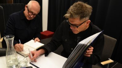 Goście spotkania podpisują książki i kronikę MBP.