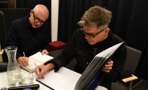 Goście spotkania podpisują książki i kronikę MBP.