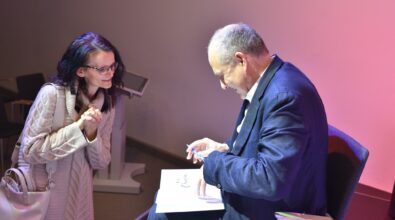 Błażej Torański podpisuje książkę uczestniczce spotkania.