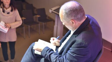 Gość spotkania podpisuje książkę