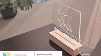 Zbliżenie na statuetkę „EkoTEKA” stojącą na stole. Na dole zdjęcia logotypy.