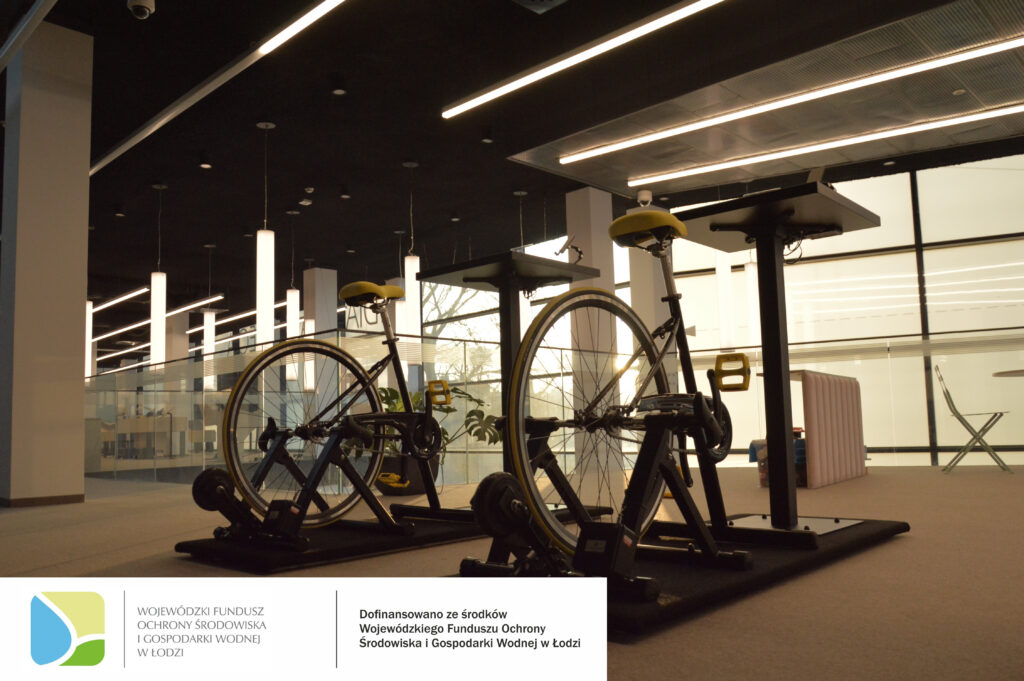 Zdjęcie rowerów biurowych do wytwarzania energię do ładowania urządzeń. Na dole zdjęcia logotypy.