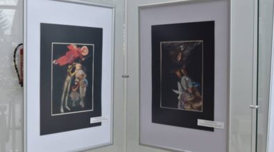 Dwie oprawione prace artystyczne zawieszone obok siebie na ścianie ekspozycyjnej, przedstawiające kobiece postacie w dekoracyjnych, symbolicznych kompozycjach. Zdjęcie ukazuje fragment wystawy „Kobiecość zdobna i wystrojona” prezentowanej w przestrzeni Miejskiej Biblioteki Publicznej.