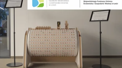 Interaktywna instalacja dźwiękowa Musicon Care+ stanowiąca nową stałą ekspozycję „Projektowanie muzyki” w Mediatece 800-lecia. Centralnie znajduje się duży, drewniany instrument z obrotowym bębnem i kolorowymi elementami dźwiękowymi, a po bokach ustawiono tablice informacyjne oraz logotyp Wojewódzkiego Funduszu Ochrony Środowiska i Gospodarki Wodnej w Łodzi.