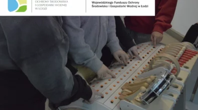 Grupa dzieci obsługuje interaktywną instalację dźwiękową Musicon Care+, naciskając przyciski i elementy sterujące w celu tworzenia własnych kompozycji dźwiękowych. W górnej części zdjęcia widoczna jest informacja o dofinansowaniu ze środków Wojewódzkiego Funduszu Ochrony Środowiska i Gospodarki Wodnej w Łodzi.
