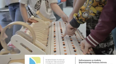 Na zdjęciu widoczne są dzieci uczestniczące w warsztatach edukacyjnych, które eksperymentują z instrumentem muzycznym, naciskając przyciski i obserwując powstające dźwięki. Zajęcia mają charakter interaktywny i rozwijają wrażliwość muzyczną oraz ciekawość poznawczą uczestników. Warsztaty realizowane są w ramach projektu EkoTEKA, dofinansowanego ze środków Wojewódzkiego Funduszu Ochrony Środowiska i Gospodarki Wodnej w Łodzi.