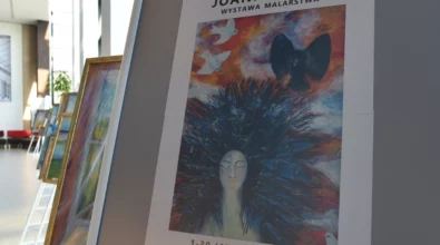 Na planszy ekspozycyjnej umieszczony jest plakat zapowiadający wystawę malarstwa Joanny Prus w Mediatece 800-lecia, z reprodukcją barwnego obrazu przedstawiającego postać kobiety na tle ekspresyjnej, abstrakcyjnej kompozycji. Grafika zawiera nazwisko artystki oraz informację o terminie wystawy.