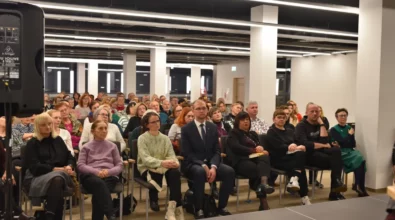 Publiczność zgromadzona w sali Mediateki uważnie słucha rozmowy prowadzonej na scenie. Uczestnicy spotkania siedzą w rzędach krzeseł, obserwując przebieg dyskusji autorskiej. W wydarzeniu biorą udział mieszkańcy miasta w różnym wieku, którzy z zainteresowaniem śledzą spotkanie literackie.