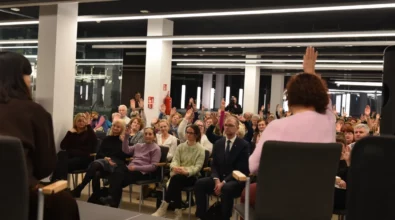 Publiczność siedząca na sali podnosi ręce, odpowiadając na pytanie zadane podczas spotkania autorskiego. Na pierwszym planie widoczne są uczestniczki rozmowy siedzące na scenie, odwrócone w stronę publiczności. W wydarzeniu bierze udział liczne grono odbiorców, którzy aktywnie włączają się w rozmowę.