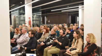 Publiczność zgromadzona w sali Mediateki uważnie słucha rozmowy prowadzonej na scenie. W pierwszym rzędzie siedzą uczestnicy wydarzenia, wśród których znajduje się realizator dźwięku w słuchawkach trzymający mikrofon. W spotkaniu uczestniczą mieszkańcy miasta w różnym wieku, którzy z zainteresowaniem śledzą przebieg dyskusji autorskiej.