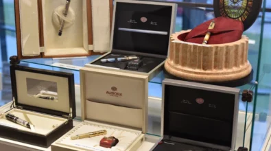 W gablocie ekspozycyjnej zaprezentowane są pióra wieczne umieszczone w eleganckich pudełkach i etui, ułożone obok siebie wraz z opisami. Zdjęcie przedstawia fragment wystawy „Historia i teraźniejszość Polski – piórem wiecznym pokazana” prezentowanej w Miejskiej Bibliotece Publicznej im. Adama Próchnika.