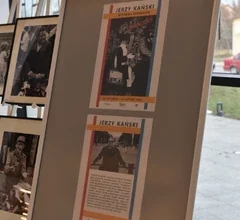 Na planszy ekspozycyjnej zaprezentowane są fotografie z podpisami i opisami, tworzące wystawę „Londyńczycy” autorstwa Jerzego Kańskiego. Zdjęcie przedstawia fragment ekspozycji prezentowanej w przestrzeni Miejskiej Biblioteki Publicznej.