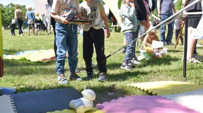 Zdjęcie przedstawiające chłopców wspólnie trzymających jednego tableta. Przed nimi znajdują się kolorowe maty piankowe, na których jeździ niewielki biały robot, prawdopodobnie sterowany przez chłopców. Zdjęcie: MBP.
