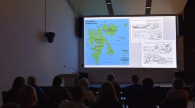 Uczestnicy wydarzenia siedzą w sali Mediateki i biorą udział w spotkaniu autorskim. Prowadzący przemawia do publiczności, odpowiada na pytania oraz prowadzi prezentację multimedialną. W trakcie spotkania panuje swobodna, życzliwa atmosfera sprzyjająca rozmowie i wymianie myśli. Zdjęcia pokazują zaangażowaną publiczność, elementy wykładu oraz momenty integracji uczestników.