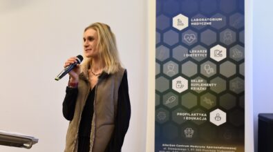 Prowadząca spotkanie przemawia do mikrofonu.