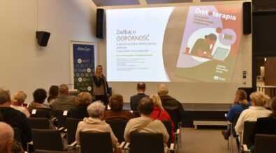 Zdjęcie publiczności, w tle prowadząca i widoczny slajd.