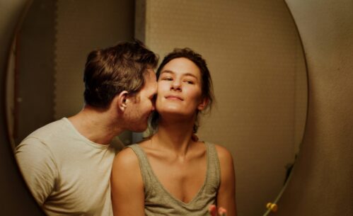 Plakat filmu „Być kochaną” przedstawiający zbliżenie dwojga dorosłych, gdzie mężczyzna pochyla się w stronę kobiety, a ona patrzy przed siebie z zamyślonym wyrazem twarzy. Na grafice widoczne są informacje o projekcji w Kinie Piksel w Mediatece 800-lecia, data 7 lutego 2026 roku, godzina 17:00 oraz oznaczenie wiekowe 15+.