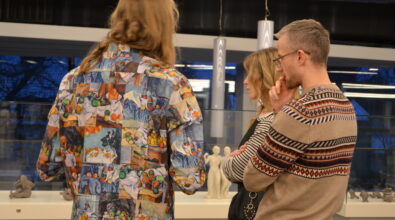 Trzy osoby rozmawiają przy ekspozycji rzeźb.