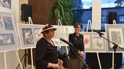 Dyrektor MBP i autorka wystawy stoją przy mikrofonach. W tle widać prace na sztalugach.