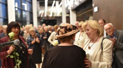 Na zdjęciu widoczny jest moment rozmowy i gratulacji po zakończeniu otwarcia wystawy, z udziałem artystki oraz uczestników wydarzenia. W tle zgromadzona publiczność wypełnia przestrzeń wystawową, a kadr oddaje ciepłą i integrującą atmosferę spotkania kulturalnego.