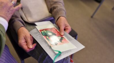 Na zdjęciu widoczny jest zbliżony kadr na dłonie uczestniczki trzymającej książkę lub katalog z ilustracją oraz wstążką. Ujęcie podkreśla kameralny charakter wydarzenia i zainteresowanie odbiorców prezentowaną twórczością.