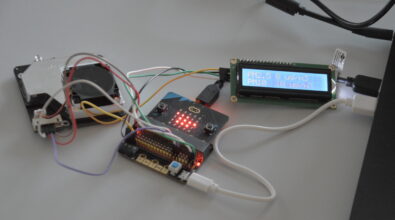 Mobilne urządzenie do pomiaru jakości powietrza zbudowane z mikrokontrolera, czujnika oraz wyświetlacza LCD. Elementy połączone są przewodami i podłączone do zasilania za pomocą kabla USB. Na ekranie wyświetlane są aktualne wartości stężenia pyłów zawieszonych PM2.5 i PM10 wyrażone w mikrogramach na metr sześcienny. Fotografia przedstawia prototyp wykorzystywany w projekcie dotyczącym monitorowania zanieczyszczeń powietrza i poprawy jakości życia mieszkańców.