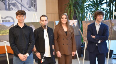 Czworo uczniów i absolwentów Zespołu Szkół Ponadpodstawowych nr 5 w Piotrkowie Trybunalskim „Fototechnika” pozuje do pamiątkowego zdjęcia podczas otwarcia wystawy w Mediatece 800-lecia. Młodzi twórcy stoją na tle swoich wielkoformatowych fotografii ustawionych na sztalugach, prezentujących m.in. pejzaże i architekturę. W tle widoczne jest nowoczesne wnętrze Mediateki z roślinnością i przeszkloną ścianą, podkreślające uroczysty charakter wydarzenia.