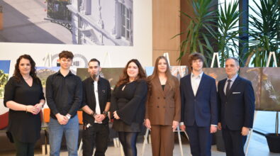 Grupowe zdjęcie uczestników i organizatorów otwarcia wystawy fotografii „Fototechnika” w Mediatece 800-lecia. Na pierwszym planie stoją uczniowie i absolwenci Zespołu Szkół Ponadpodstawowych nr 5 w Piotrkowie Trybunalskim wraz z przedstawicielami szkoły i Mediateki. W tle widoczne są wielkoformatowe fotografie ustawione na sztalugach, prezentujące pejzaże, architekturę oraz detale natury. Nowoczesne wnętrze Mediateki z wysokimi oknami i roślinnością podkreśla uroczysty charakter wydarzenia.