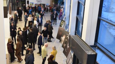 Widok z antresoli na hol Mediateki 800-lecia podczas otwarcia wystawy fotografii uczniów i absolwentów Zespołu Szkół Ponadpodstawowych nr 5 w Piotrkowie Trybunalskim „Fototechnika”. Wzdłuż przeszklonej ściany ustawione są na sztalugach wielkoformatowe fotografie, które oglądają licznie zgromadzeni goście. Uczestnicy wydarzenia spacerują między ekspozycjami, rozmawiają i zatrzymują się przy wybranych pracach. Nowoczesne, jasne wnętrze budynku z wysokimi oknami i industrialnym oświetleniem podkreśla uroczysty charakter spotkania.