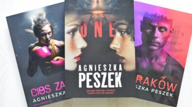 Trzy egzemplarze książki autorstwa Agnieszka Peszek ustawione obok siebie, lekko pod kątem. W centrum znajduje się książka z wyraźnym tytułem „ONE”. Okładka przedstawia zbliżenia twarzy młodych osób skierowanych w różnych kierunkach, utrzymane w chłodnej kolorystyce. Po lewej stronie widoczna jest książka w odcieniach różu i fioletu z fragmentem tytułu „…es za”, a po prawej egzemplarz w ciemniejszych, purpurowych barwach z widocznym fragmentem tytułu „Rak…”. Wszystkie okładki tworzą spójną serię graficzną z portretami bohaterów i intensywnymi kolorami tła.