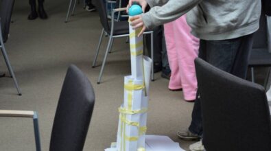 Wysoka wieża z papieru, starannie złożona, sięgająca w górę, z delikatnymi detalami i teksturą papieru.