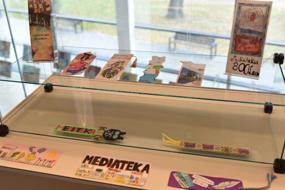 Jasna szklana gablota z zakładkami w różnych kolorach i stylach wykonanymi na konkurs.