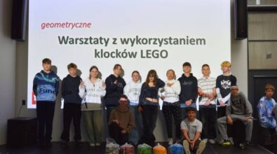 Wspólne zdjęcie uczestników na tle ekranu projekcyjnego.