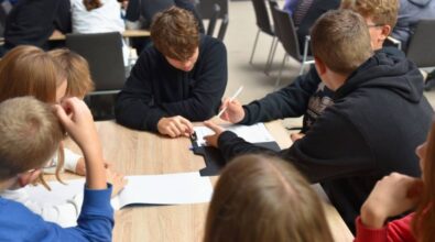 Przy stoliku uczestnicy wypełniają formularz.