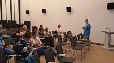 Uczestnicy szkolenia pracują na telefonach komórkowych. W tle widać osobę prowadzącą.