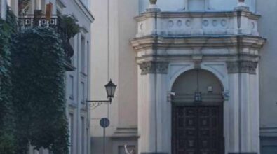 Widok Sanktuarium Matki Bożej Trybunalskiej. Przed budynkiem stoi kobieta i robi zdjęcia telefonem.