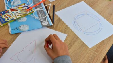 Stolik z materiałami potrzebnymi do warsztatów, na kartkach narysowane figury geometryczne.