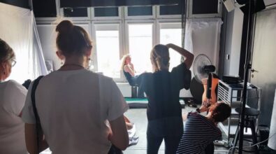 Zdjęcie przedstawia grupę ludzi w studio fotograficznym, skoncentrowanych na robieniu zdjęć.