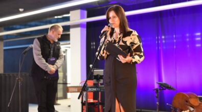 Osoba prowadząca przemawia do mikrofonu na scenie.