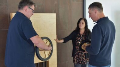 Trzy osoby sprawdzają eksponat.