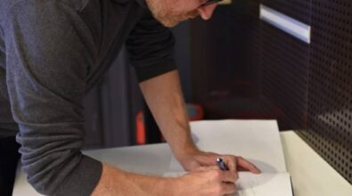 Gość wieczoru Rober Małecki wpisuje się do kroniki biblioteki.