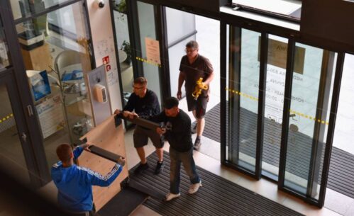 Grupa ludzi wnosi eksponat do Mediateki.