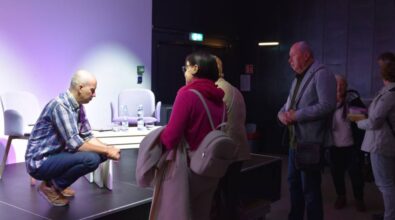 Piotr Milewski rozmawia z ludźmi po oficjalnej części spotkania. W kolejce stoją osoby trzymające książki.