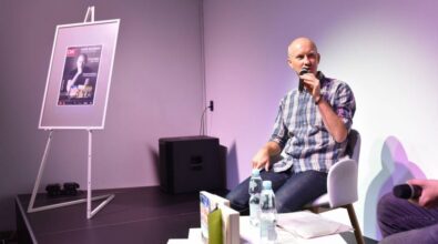 Widok na jednego z mężczyzn, Piotra Milewskiego, który przemawia do mikrofonu.