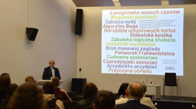 Autor przemawia do publiczności. Na ekranie slajd z prezentacji o historii kostki Rubika..