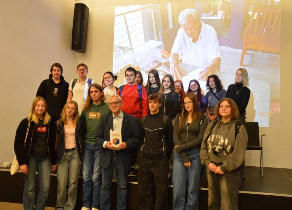 Autor książki pozuje do zdjęcia z grupa uczniów, którzy przyszli na spotkanie.